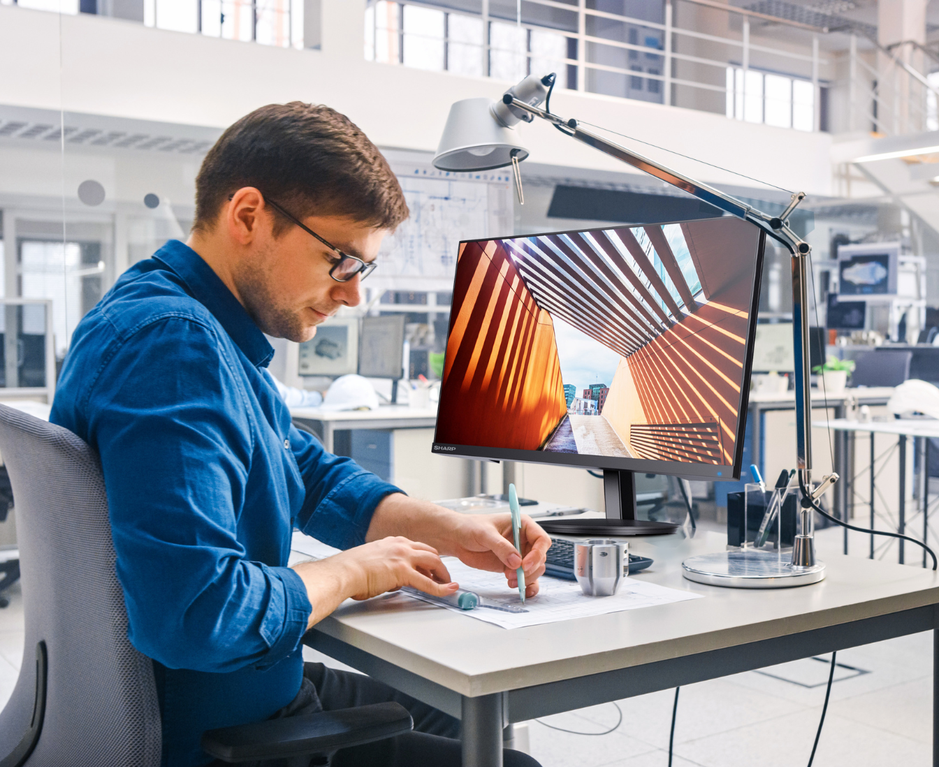 a person using a desktop monitor at his desk