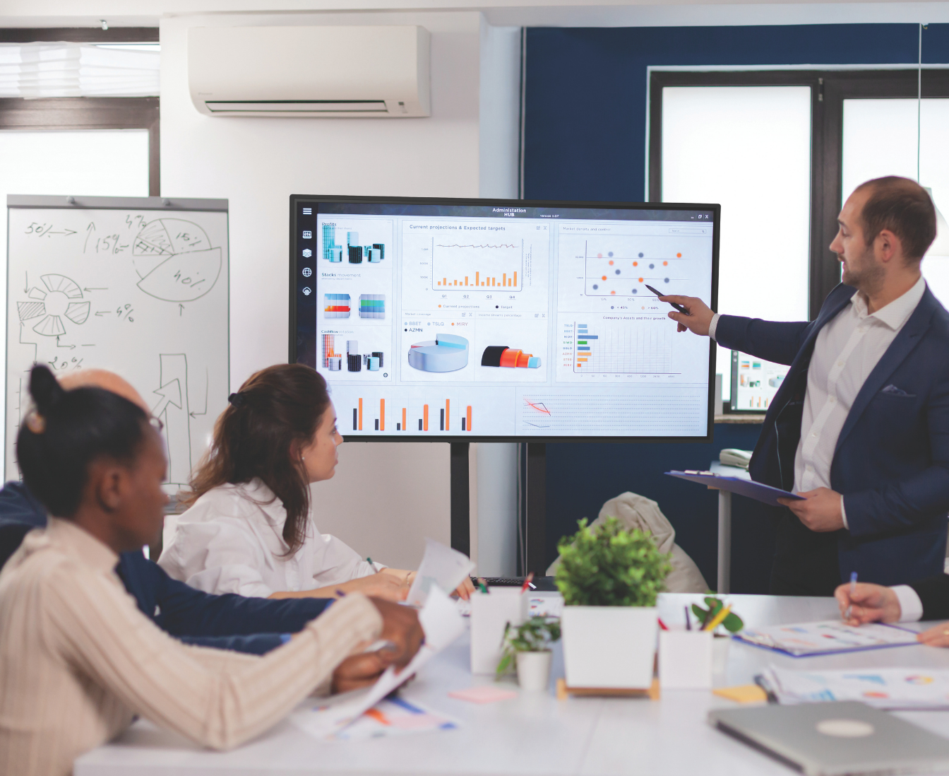 touch screen in a business meeting with a man pointing to screen